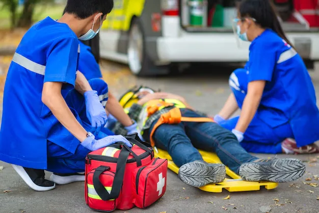 Paramedics providing immediate emergency care to an accident victim, representing the 24/7 rapid response trauma services at Neuron Plus Hospital.