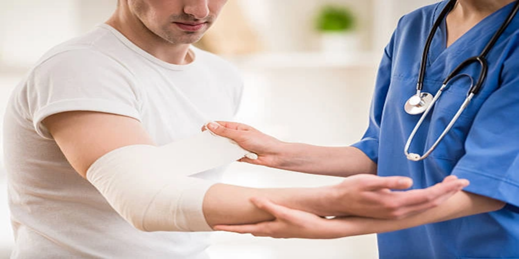 Orthopedic doctor applying a bandage to a patient's injured arm, illustrating expert fracture management and industrial injury treatment.